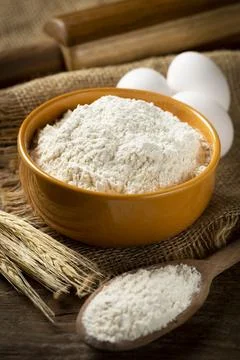 Bowl with wheat flour on the table. Stock Photos