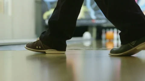 Bowler rolls bowling ball down a lane Stock Footage