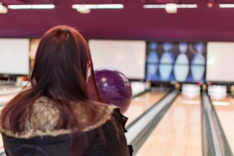 A bowling ball while being aimed to the target by a female adult in a bowling Stock Photos