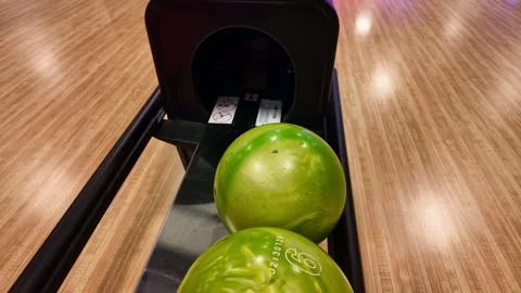 Bowling balls in a ball return machine at an alley Stock Footage 332074726