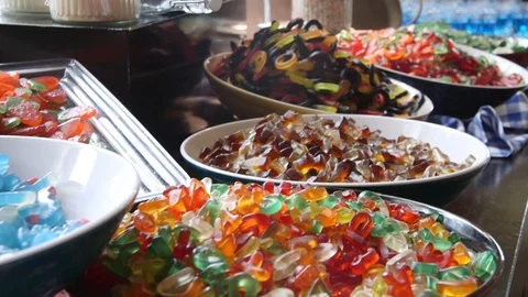 Bowls Of Different Kinds Of Candy Such As Cola Bottles, Strawberries And Smurfes Stock Footage 126701039
