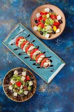 Bowls filled with different types of food including Caprese, Greek and vegeta Stock Photos