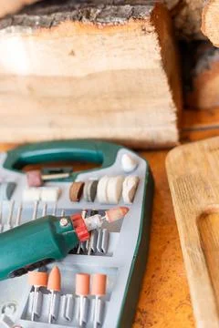 Box with accessories for processing and engraving next to an electric tool. h Stock Photos