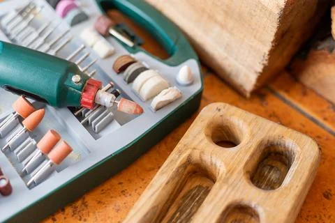 Box with accessories for processing and engraving next to an electric tool. h Foto stock