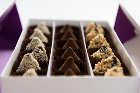 In the box are rows of different chocolates. A gift or greeting. Festive dess Stock Photos