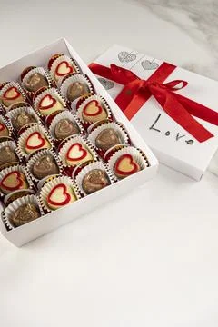 Box of assorted chocolates with the lid open and a red bow vertical. Stock Photos