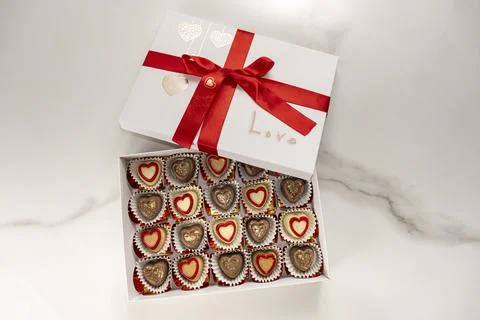 Box of assorted chocolates with a red bow and the word love. Stock Photos