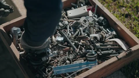 Box of assorted metal hardware parts outdoors Stock Footage 331975077