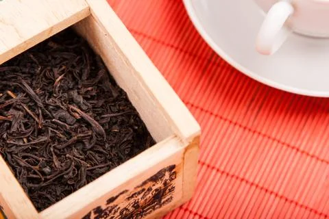 Box with black tea on red mat Stock-Fotos