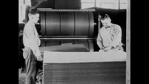 Box blanks are formed using huge presses at a paper mill in the 1920s. Stock Footage 99361604