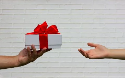 Box with a bow in elderly hands Stock Photos