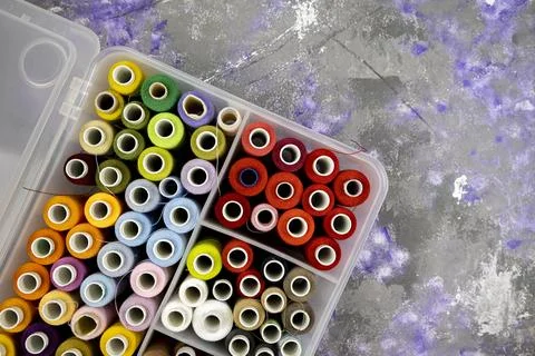 Box with bright colored threads on an abstract background, top view, space fo Stock Photos