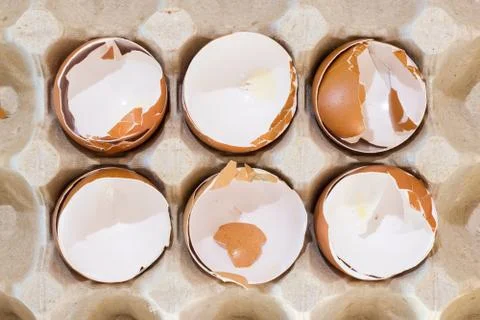 Box with broken eggshell brown chicken eggs, background texture pattern Stock Photos