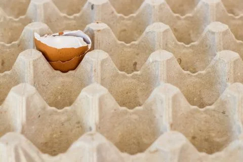 Box with broken eggshell brown chicken eggs, background texture pattern Stock Photos