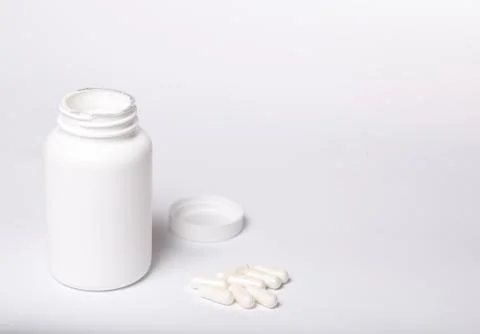 Box with capsules on a white background Stock Photos