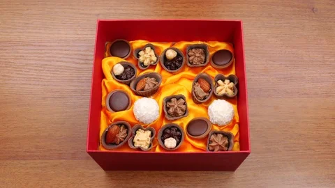 A box of chocolates on the table. Many hands taking candy from a box Video stock 72247213