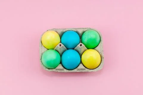 Box with colorful Easter eggs on a pink background Stock Photos