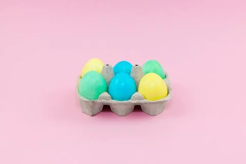 Box with colorful Easter eggs on a pink background Foto stock
