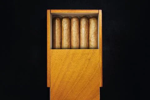 Box of Cuban Cigars on black table in the dark. Expensive premium cigars as a Stock Photos