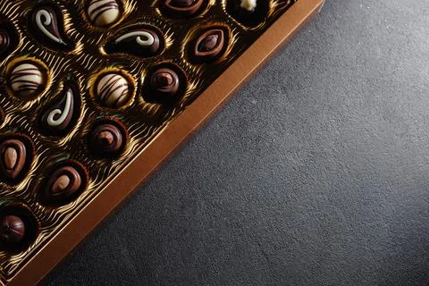 A box of different chocolates. Chocolate assortment mix on the black table, top 写真素材
