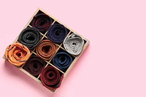 Box with different stylish ties on pink background Stock Photos
