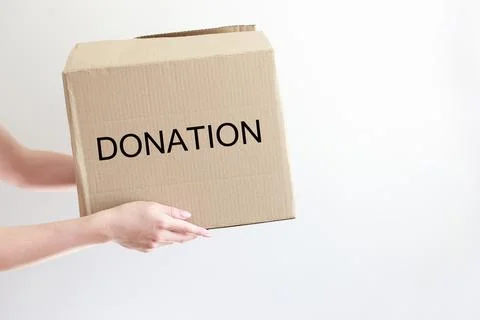 Box with donations in hands on a white background Foto stock