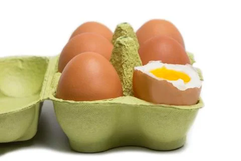 Box of eggs with one broken boiled egg Stock Photos