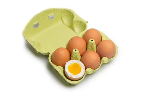 Box of eggs with one broken boiled egg Stock Photos