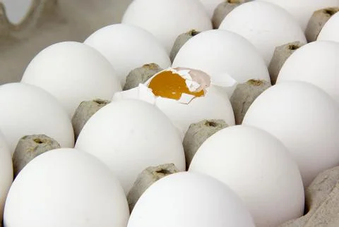 Box of eggs. one cracked. Stock Photos