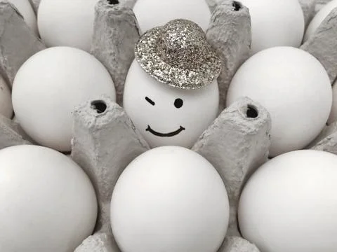 A box of eggs. Smiling egg in the hat. Stock Photos