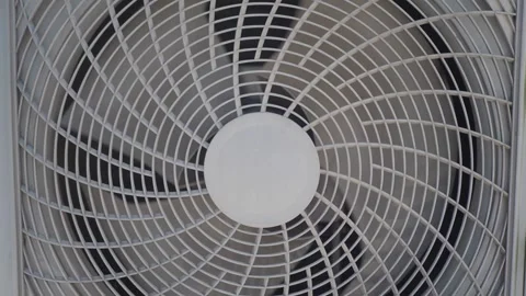Box fan spinning fast in window close-up, generating cool air flow and summ.. Vídeos de archivo 332746236
