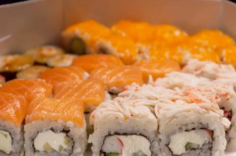 Box filled with assorted sushi rolls, a staple food in Japanese cuisine Stock Photos