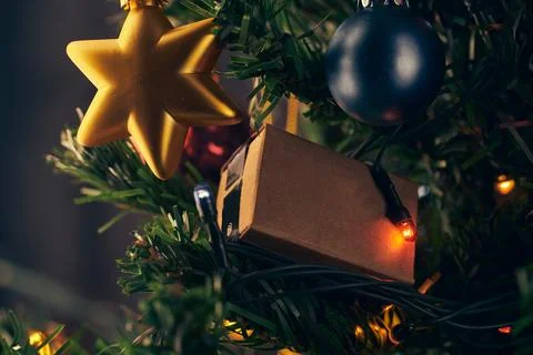 Box with a gift on the christmas tree Stock Photos
