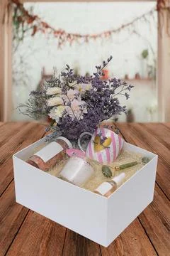 Box with gift jars, a candle and a cup on decorative hay on the background of Stock Photos