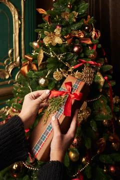 Box with a gift, a red red bow in female hands on the background of a beautiful  Stock Photos