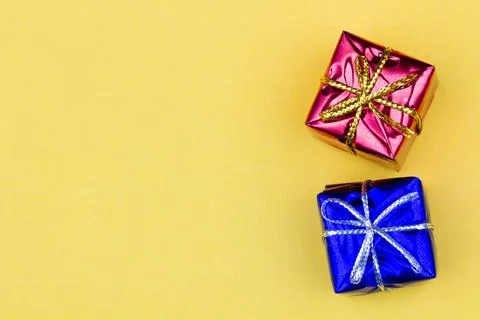 Box with gift on a yellow background with copy space for text. Red and blue Stock Photos