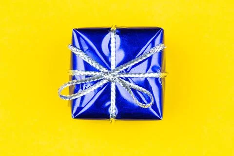 Box with gift on a yellow background with copy space for text. Blue boxes Stock Photos