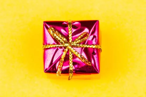Box with gift on a yellow background with copy space for text. Red boxes Stock Photos