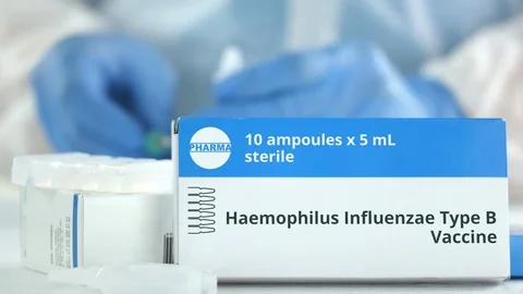 Box with haemophilus influenzae type B vaccine on the table against blurred lab Stock Footage 126882383