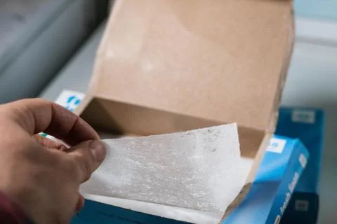 Box of laundry dryer sheets being placed on top of a dryer 스톡 사진