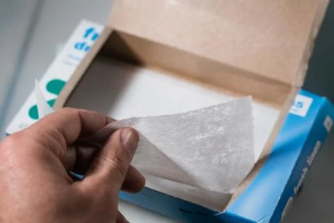 Box of laundry dryer sheets being placed on top of a dryer Stock Photos