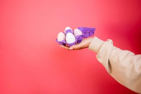 Box of light eggs in hand on pink background isolation Stock Photos
