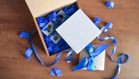 Box is opened with a gift of a blue book Stock Photos