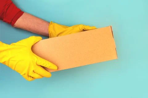 Box with ordered goods in the hands of a courier. Stock Photos