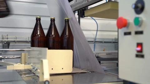 Box packaging of glass brown large bottles with beer, lemonade. Shrink machine. Stock Footage 127310826