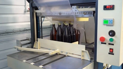 Box packaging of glass brown large bottles with beer, lemonade. Shrink machine. Stock Footage 127312067