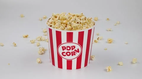 A box of popcorn falls on the table in slow motion Stock Footage 242789479