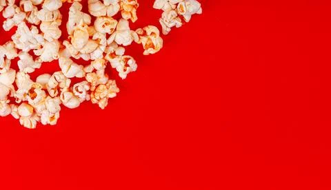 Box with popcorn on a red background Stock Photos