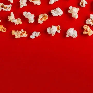 Box with popcorn on a red background Stock Photos