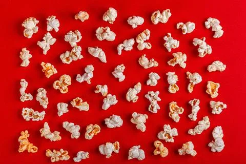 Box with popcorn on a red background Stock Photos